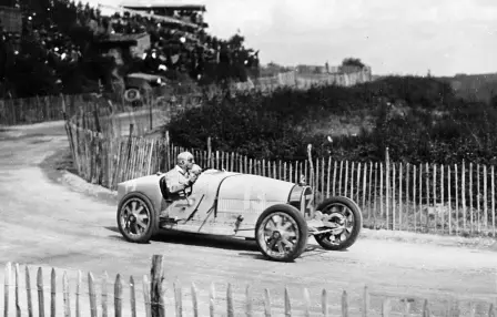 Ernest Friderich (Nr. 13) am Steuer eines Type 35 bei der Ausfahrt aus der „Virage de la Mort“ auf der kurvenreichen Abfahrt nach „Les Sept Chemins“ des Grand Prix 1924.